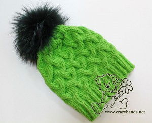 Green cable knit hat for winter with dark green raccoon fur pom pom