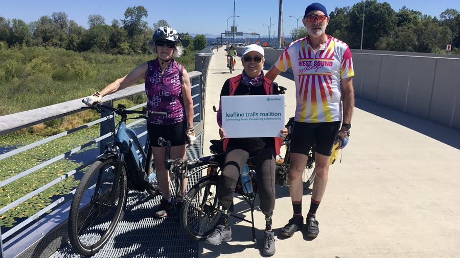 West Sound Cycling Club members on the 520 Trail, posed in front of an adaptive tandem and an ebike
