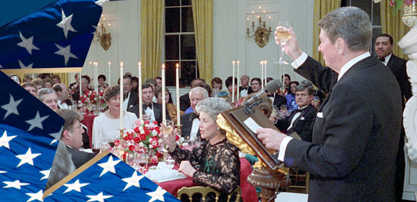 President Reagan is toasting guests with a glass of wine during a White House dinner.