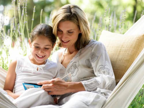 Mother and daughter reading on a hammock