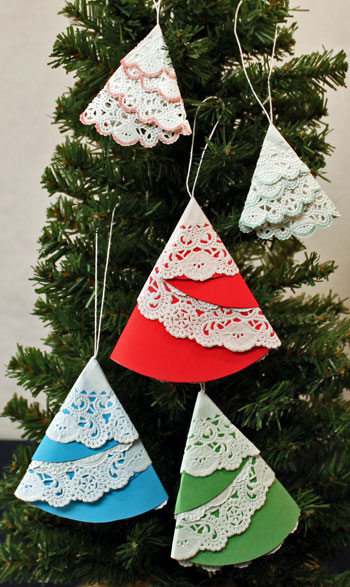 Easy Christmas Crafts Paper Doily Folded Christmas Tree Ornament showing five finished and hanging on tree