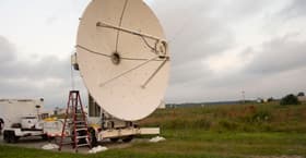 A microwave dish transmitter is pointed toward a rectifying antenna in part of the Safe and Continuous Power Beaming – Microwave (SCOPE-M) demonstration