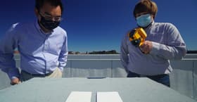 Xiulin Ruan (left) and Joseph People (right) test out samples of the new cooling paint