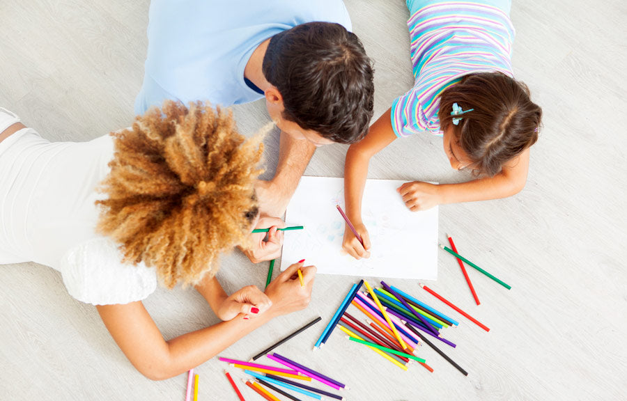 Kids coloring on paper with colored pencils