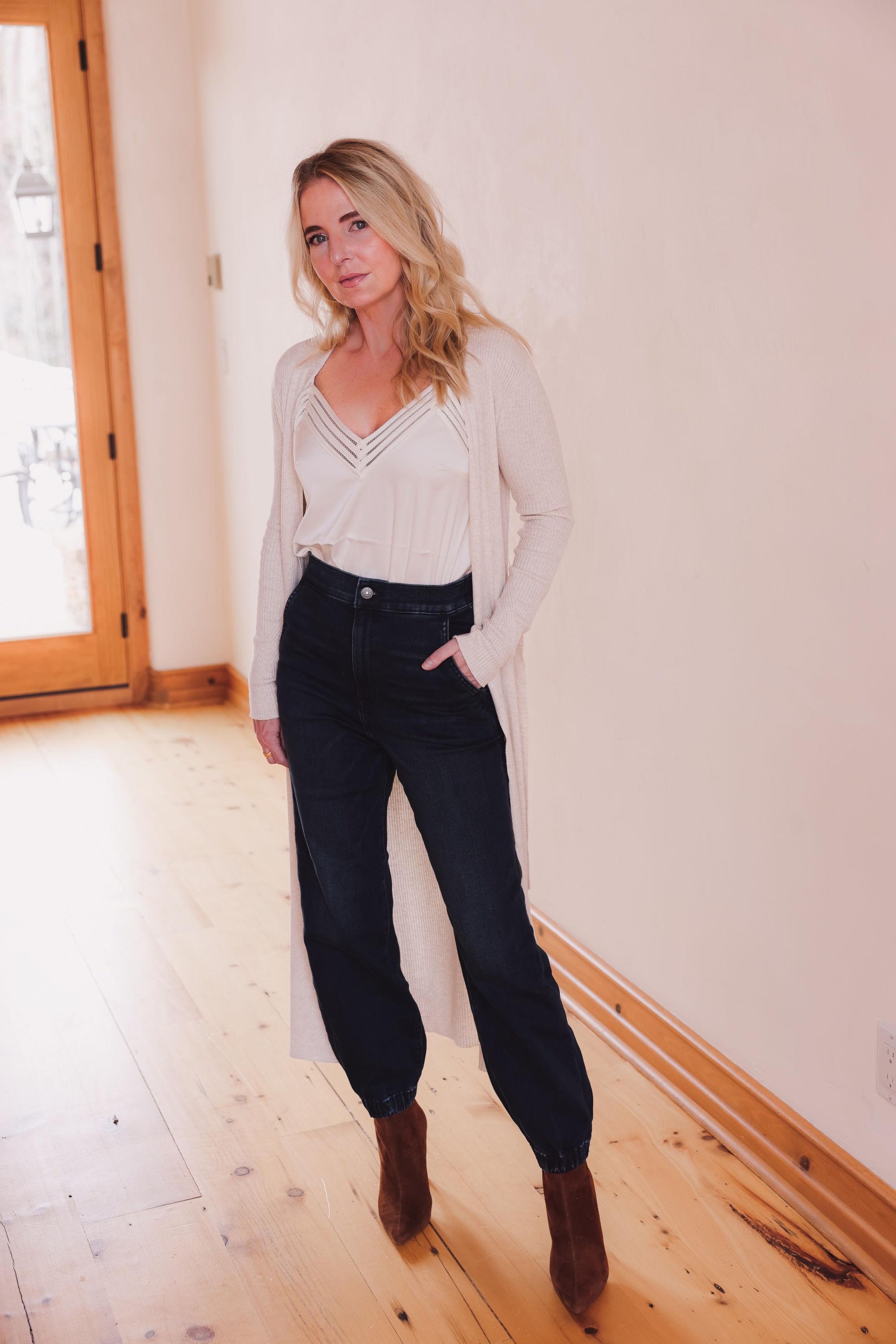Express Sale, Erin Busbee of Busbee wearing denim joggers, a white satin cami, and long ribbed duster cardigan from Express with Steve Madden brown booties in Telluride, Colorado