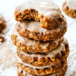 a stack of pumpkin oatmeal cookies with icing with a bite out of a cookie