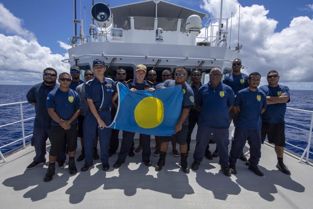 Charles Maynard of the Royal Navy, serving as deputy mission commander of Pacific Partnership (PP22), center left, takes a photo with the crew of Palau Patrol Ship PPS Kedam