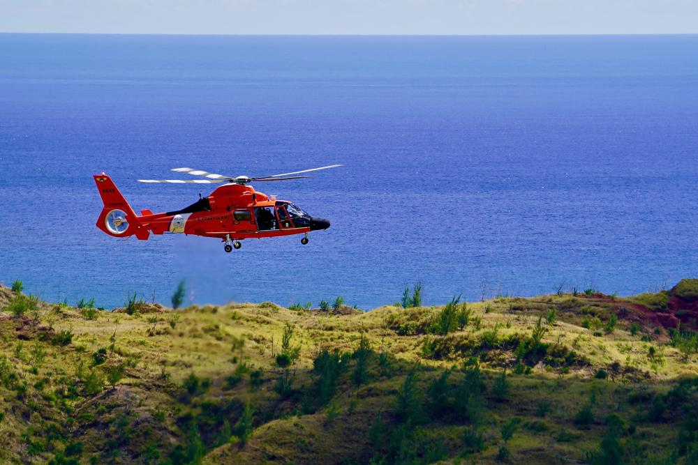 An MH-65 Dolphin helicopter crew deployed to Guam from U.S. Coast Guard Air Station Barbers Point in Hawaii flies patterns to assess winds and terrain before conducting rescue hoist training at Sella Bay Overlook in Guam on March 8, 2023.