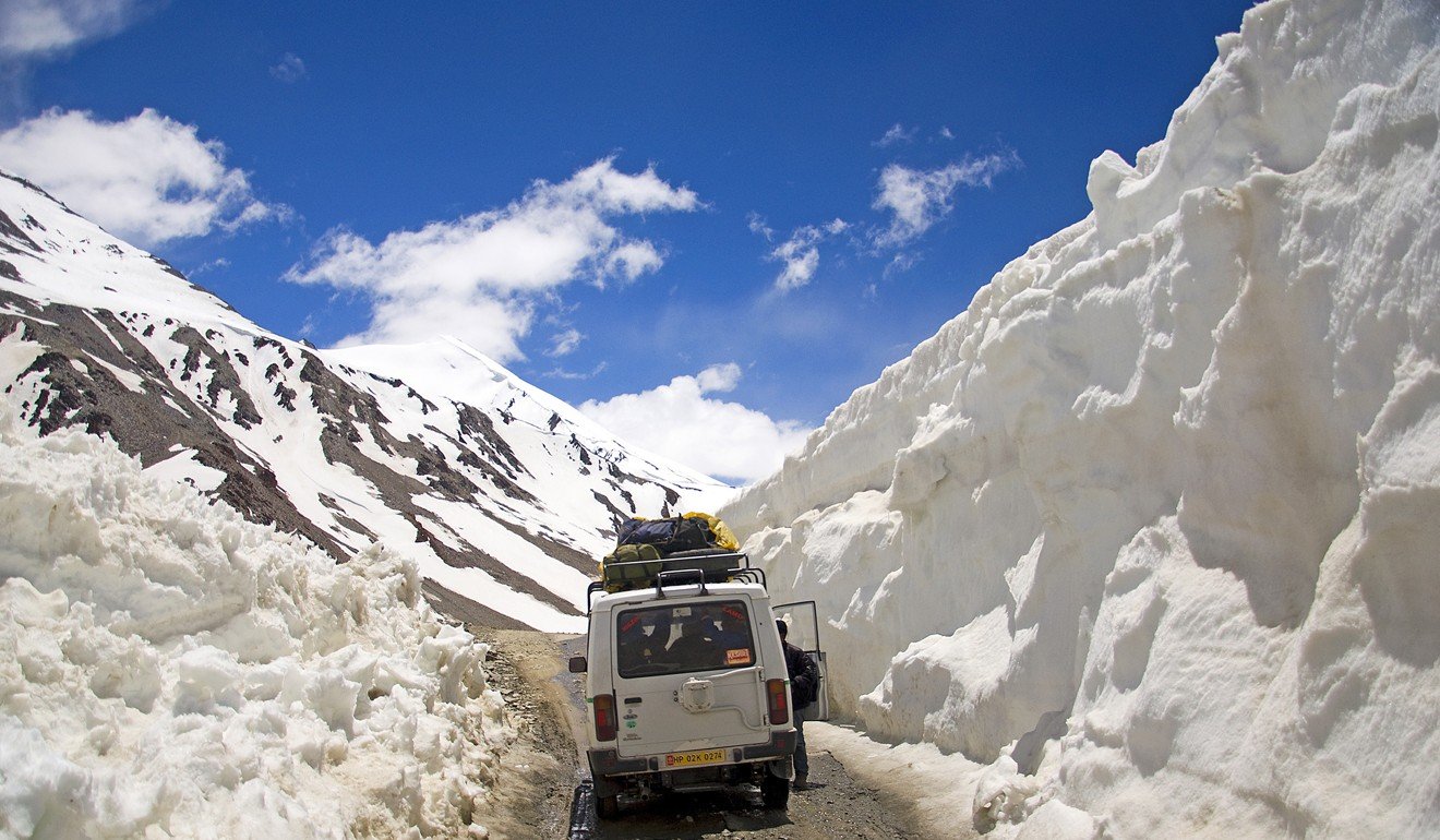 A van negotiates a road fringed by deep snow. Diminishing snowfall is evidence of the impact of climate change in Ladakh. Photo: Tim Pile