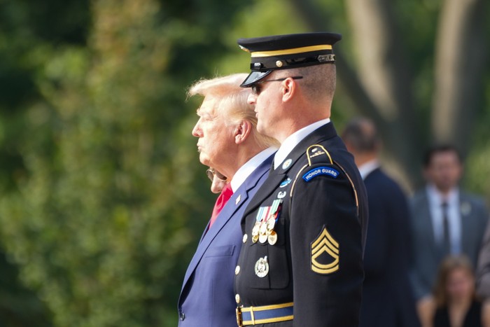 Donlad Trump stands next to an Honor Guard member during a visit to the Arlington National Cemetery