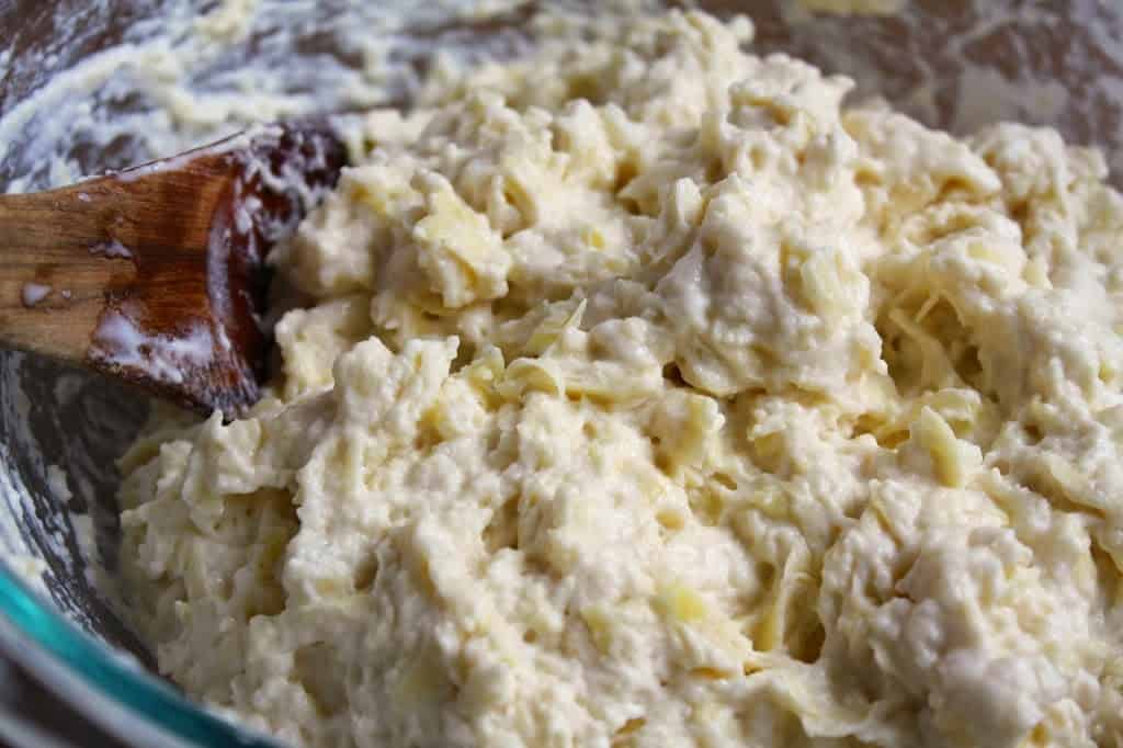 mixing raw and cooked potatoes in a bowl
