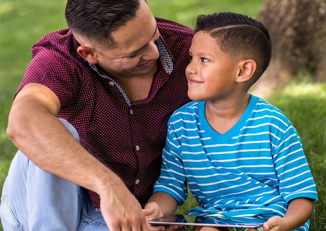 Father and son playing on tablet