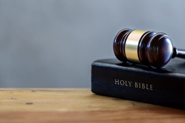 A gavel rests on top of a closed Bible. © By doidam10/stock.adobe.com