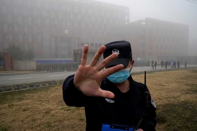 FILE - A security person moves journalists away from the Wuhan Institute of Virology after a World Health Organization team arrived for a field visit in Wuhan in China's Hubei province on Feb. 3, 2021. (AP Photo/Ng Han Guan, File). The US Energy Department has concluded that the COVID-19 pandemic origin was most likely a lab leak.