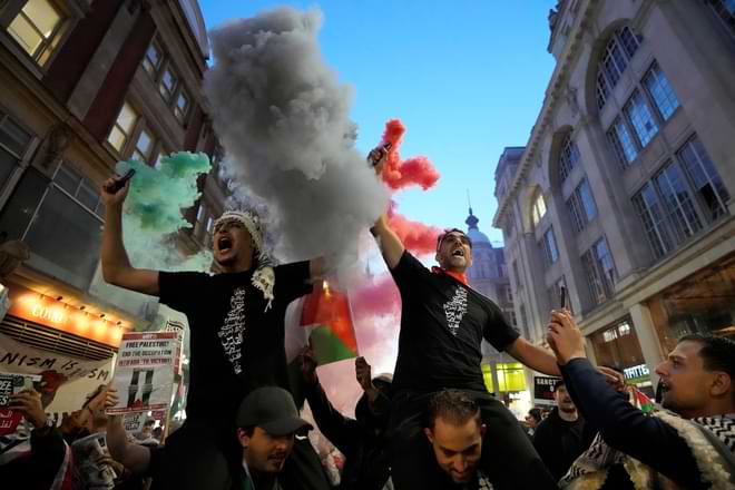 Palestinian supporters light flares during a demonstration in London, Monday, Oct. 9, 2023, two days after Hamas fighters launched a multi-front attack on Israel. (AP Photo/Kirsty Wigglesworth, File)
