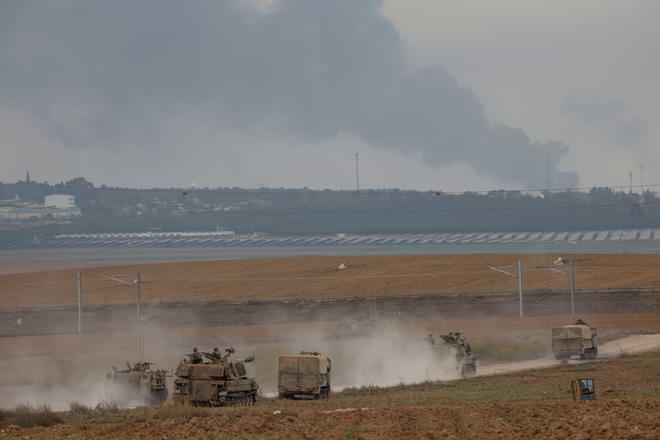 Israeli army vehicles move near the Israeli-Gaza border, southern Israel, Monday, Oct. 9, 2023.(AP Photo/Oren Ziv)