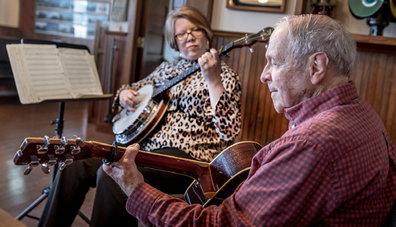 Two people playing instruments inside