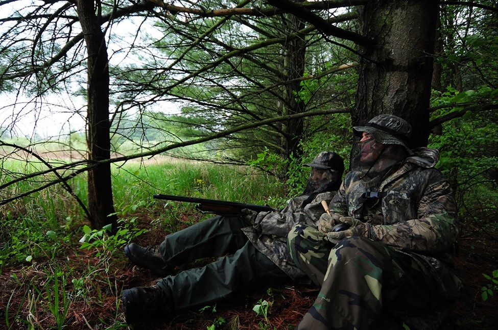 Turkey hunters camouflaged in the woods