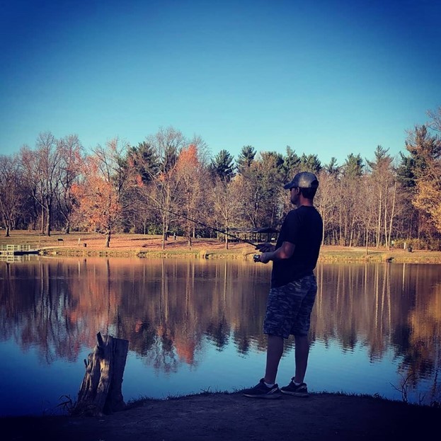 Angler casting a line with fall colors in the background