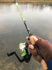 Angler with gloved hands holding a rod