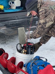 Ice fisherman packing up his equipment to head out onto the ice