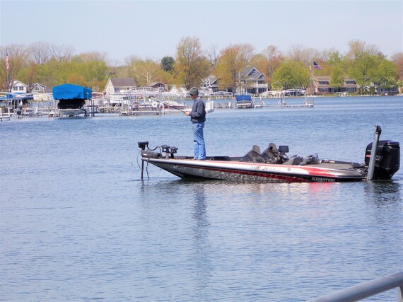 A man standing on a boat in water.