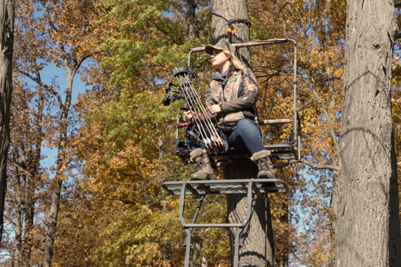 A woman hunting from a tree stand.