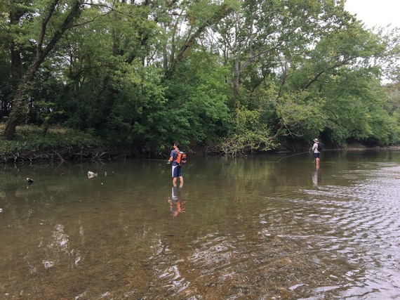 Two men stream fishing.