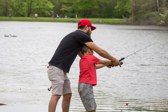 Two people holding a fishing rod.