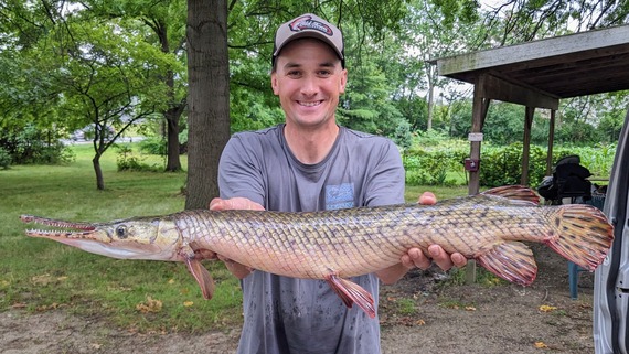 Hammond holding a large spotted gar.