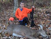 young hunter with a doe he harvested