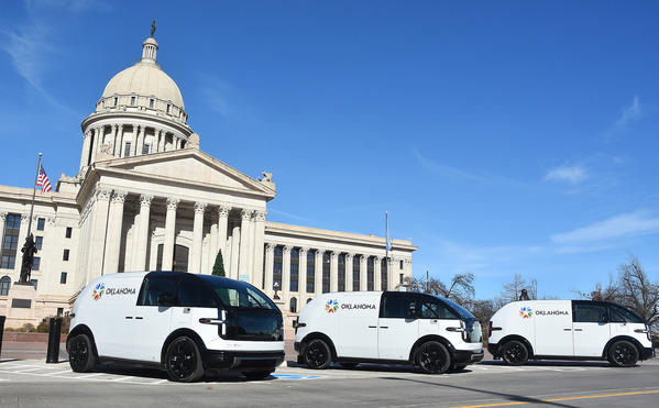 Three canoo vehicles in front of the Oklahoma Captiol Building
