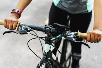 young woman holding bike handlebars