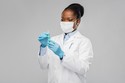 Black woman in lab coat with mask