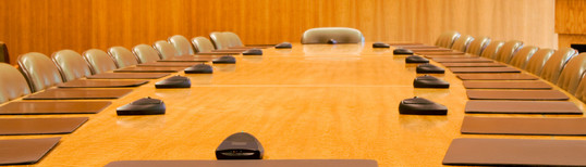 photo of desk and chairs in large conference room