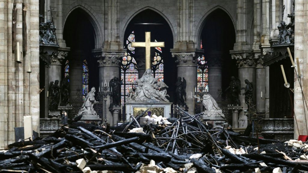 Notre Dame Entre humo y escombros se aprecia la cruz, que sobrevivió al incendio. / AFP