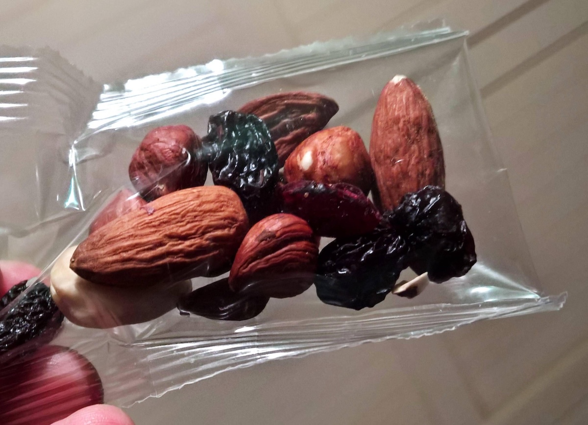 A small plastic bag filled with nuts and dried fruit.