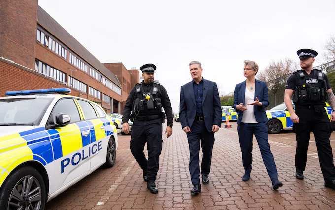 Keir Starmer, leader of the Labour Party, and Yvette Cooper, Shadow Home Secretary, speak to police officers during a visit to Milton Keynes