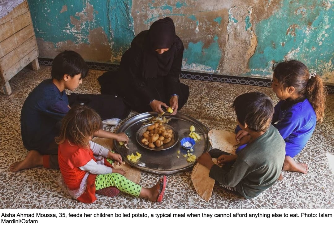 Aisha Ahmad Moussa, 35, feeds her children boiled potato, a typical meal when they cannot afford anything else to eat