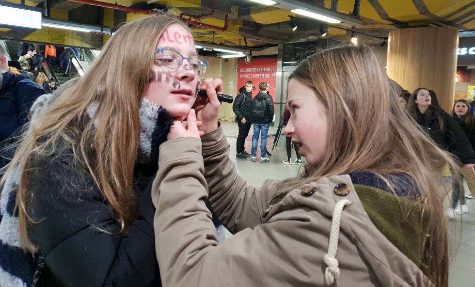 Una alumna pinta la cara de una compaera rumbo a una de las protestas en Bruselas.