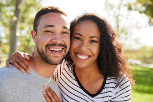 Outdoor Head And Shoulders Portrait Of Smiling Couple In Park