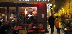 People pass by the "Casa Nostra" restaurant, one of the targets of the November 13 attack in Paris, on February 5, 2016 during the reopening of restaurant, three months after the terrorist assault in the east of the capital. - The owner of the restaurant Dimitri Mohamadi is suspected of having sold video-surveillance images of the restaurant during the attack to the British tabloid Daily Mail for 50,000 euros. (Photo by PATRICK KOVARIK / AFP)