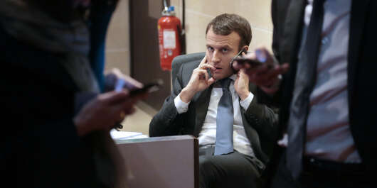 French Economy and Industry Minister Emmanuel Macron gives a phone call prior to a hearing at the French Parliament in Paris on March 11, 2015 related to US group General Electric's planned 12.4-billion-euro ($14.1-billion) acquisition of the energy business of its French rival Alstom. 
                            AFP PHOTO/JACQUES DEMARTHON (Photo by JACQUES DEMARTHON / AFP)