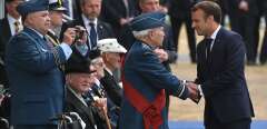 French President Emmanuel Macron (R) shakes hands with a veteran as he returns to his seat during an event to commemorate the 75th anniversary of the D-Day landings, in Portsmouth, southern England, on June 5, 2019. - US President Donald Trump, Queen Elizabeth II and 300 veterans are to gather on the south coast of England on Wednesday for a poignant ceremony marking the 75th anniversary of D-Day. Other world leaders will join them in Portsmouth for Britain's national event to commemorate the Allied invasion of the Normandy beaches in France -- one of the turning points of World War II. (Photo by Mandel NGAN / AFP)