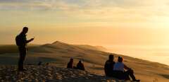 People watch the sunset on top of the dune of Pilat (or Pyla), the highest sand dune in Europe, on November 23, 2017 at La Teste-de-Buch in the Arcachon bassin, southwestern France. (Photo by Nicolas TUCAT / AFP)