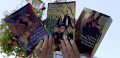 Une lectrice assidue des aventures de Harry Potter présente le 24 août 2000 à Caen les trois romans de JK Rowling devenue célèbre dans le monde entier. Agée de 34 ans, l'écrivain britannique est devenue multi-millionnaire avec les aventures de Harry Potter, l'orphelin magicien héros d'une série de livres pour enfants. Un quatrième livre devrait sortir en décembre prochain en même temps que le film tiré de ses oeuvres. (Photo by MYCHELE DANIAU / AFP)