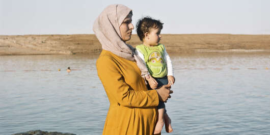 Une femme palestinienne contemple l'horizon avec son petit garçon, sur le rivage de Kalia beach