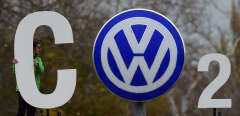 (FILES) In this file photo taken on November 9, 2015, an activist of environmental organisation Greenpeace holds a giant letter to display "CO2" around the logo of German car maker Volkswagen (VW) at the entrance of the company's headquarters in Wolfsburg, northern Germany. - German prosecutors said on September 24, 2019 they had charged Volkswagen chief executive Herbert Diess, former boss Martin Winterkorn and supervisory board chief Hans Dieter Poetsch with "market manipulation" relating to the car giant's "dieselgate" scandal. (Photo by John MACDOUGALL / AFP)