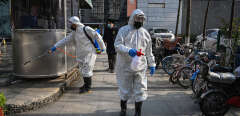 People dressed in protective clothes disinfect an area in Wuhan, in Hubei province on January 29, 2020. - The World Health Organization, which initially downplayed the severity of a disease that has now killed 170 nationwide, warned all governments to be "on alert" as it weighed whether to declare a global health emergency. (Photo by Hector RETAMAL / AFP)