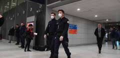 Policemen wearing protective face masks patrol in the arrival Terminal in Charles De Gaulle Airport on January 26, 2020 in Roissy-en-France. - China expanded drastic travel restrictions to contain a viral epidemic that has killed 56 people and infected nearly 2,000, as the United States and France prepared to evacuate their citizens from a quarantined city at the outbreak's epicentre. (Photo by Alain JOCARD / AFP)